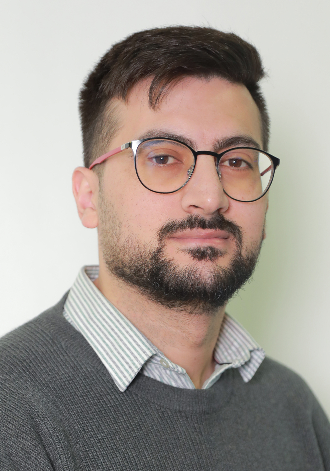 Photo of man with glasses smiling.